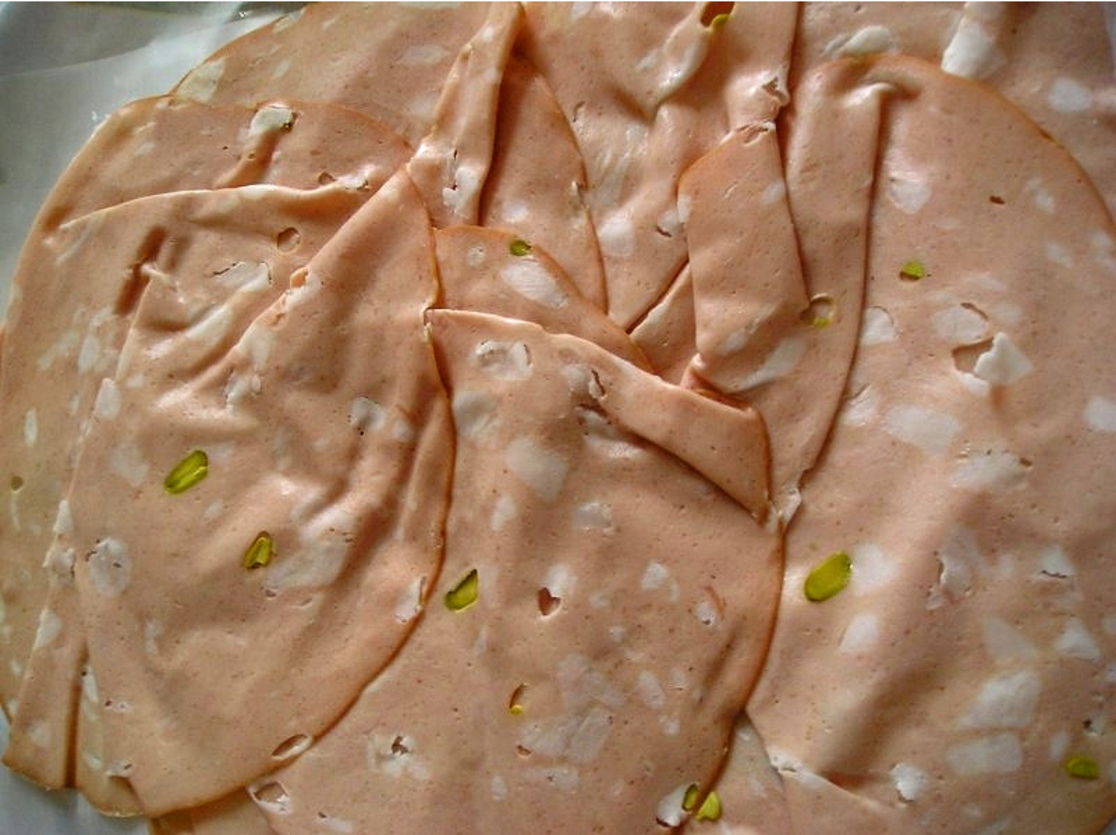 Wikipedia's Mortadella article showing a photo of sliced Mortadella Bologna PGI with visible cubes of pork fat
