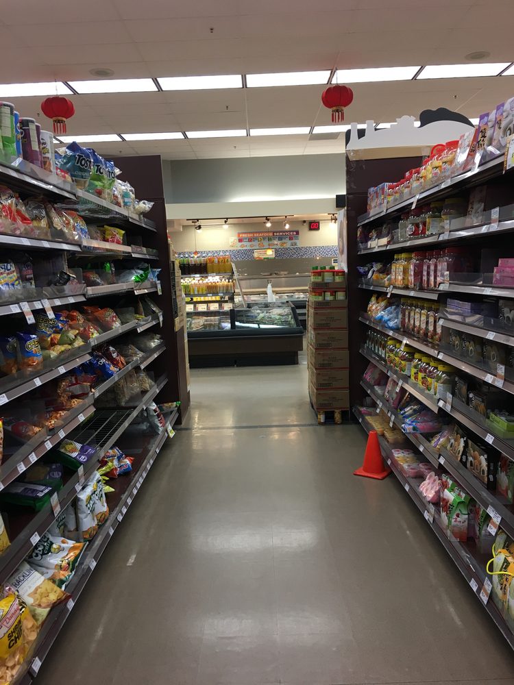 The interior grocery aisle of a 99 Ranch Market supermarket, with red paper lanterns hanging and a fresh seafood counter visible