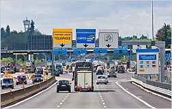 Wikipedia's Autostrade of Italy article showing a photo of cars and trucks passing through a highway toll station with Telepass and cash lanes