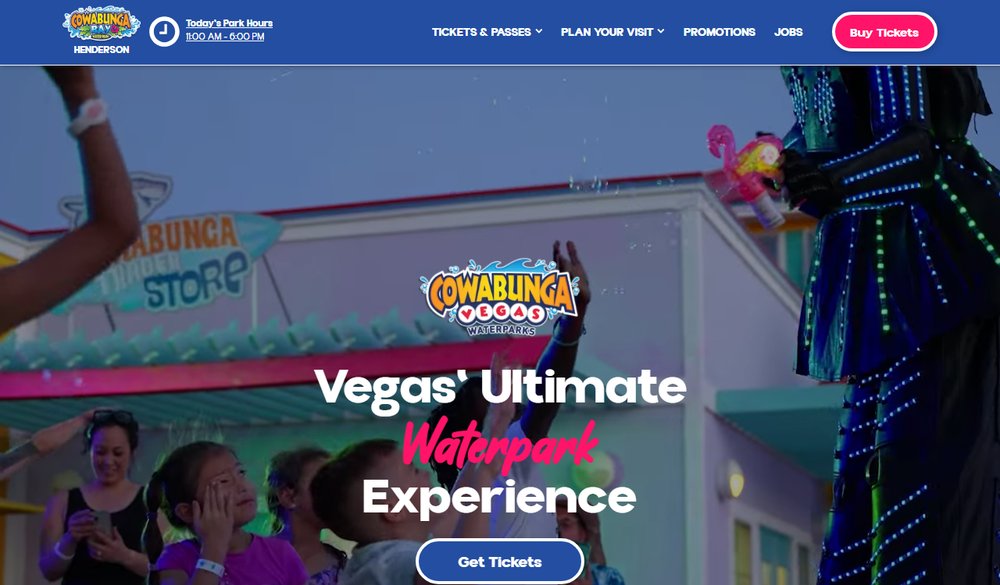 The Cowabunga Bay Henderson homepage, reading 'Vegas' Ultimate Waterpark Experience' over a photo of costumed performers and guests celebrating
