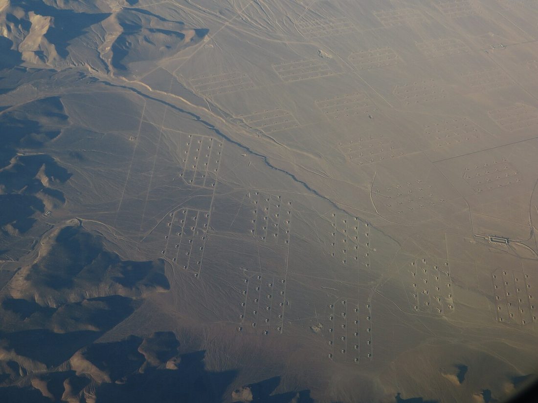 An aerial view of the Hawthorne Army Depot in Nevada, showing hundreds of ammunition storage bunkers arranged in grid patterns across the desert valley floor