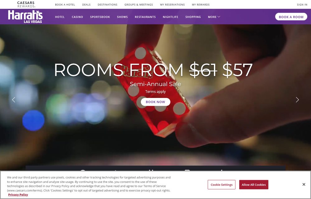 Harrah's Las Vegas's own homepage hero, showing a close-up of a hand rolling red casino dice with the Strip's lights blurred in the background