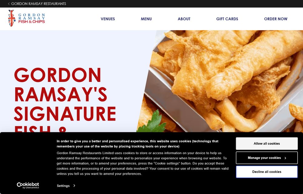 A close-up of Gordon Ramsay's British-style fish and chips, golden battered fish and thick-cut fries served in a metal tray