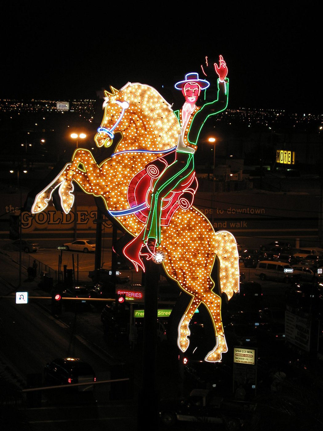 The Hacienda Horse and Rider neon sign, showing a cowboy on a rearing golden horse, illuminated at night on North Las Vegas Boulevard near Fremont Street