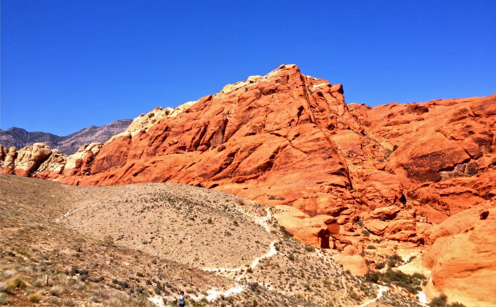 A scenic overlook viewpoint of the red and white banded Calico Hills sandstone formations at Red Rock Canyon, seen from a roadside pullout