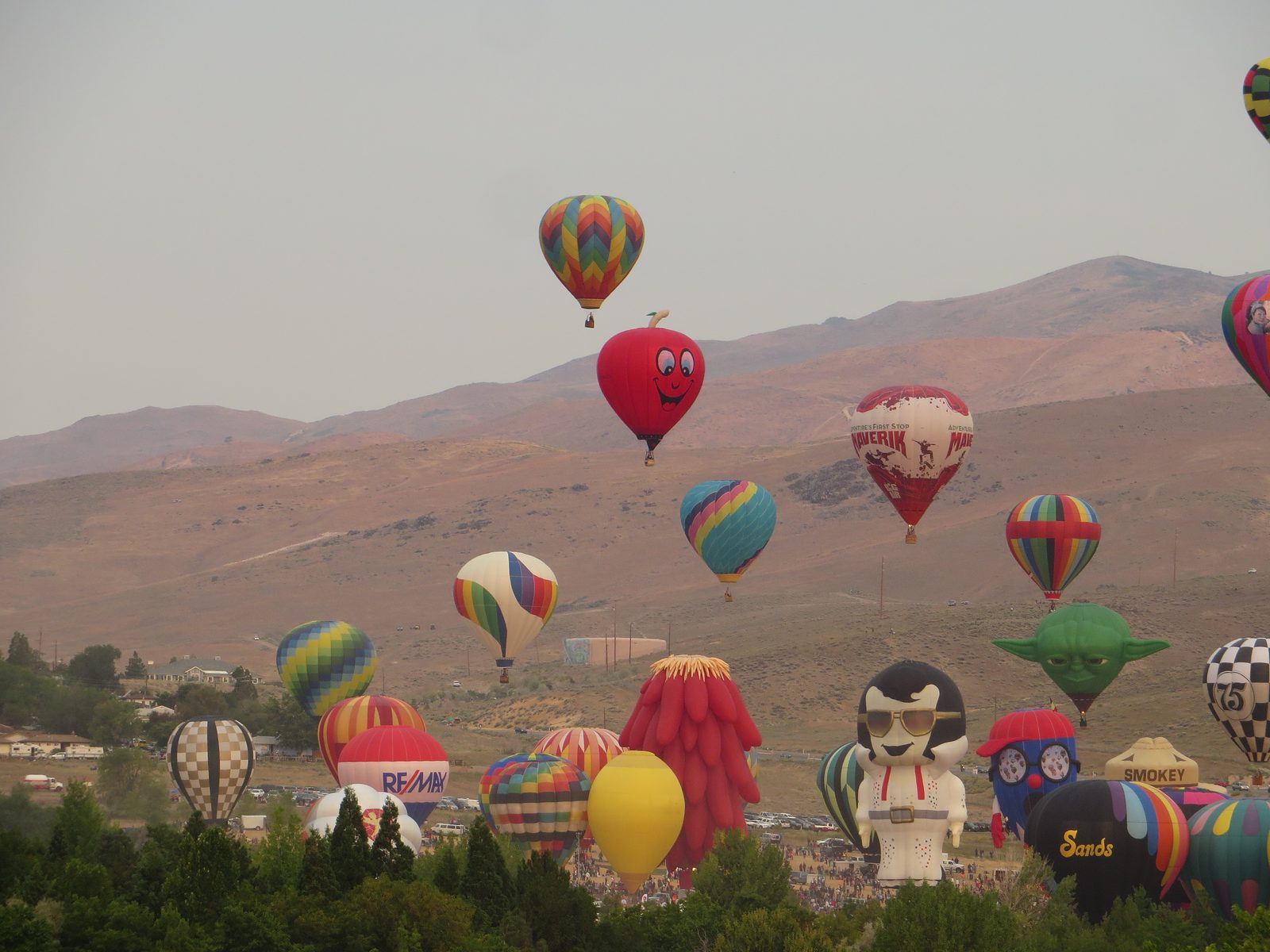 Dozens of colorful hot air balloons filling the sky above the Great Reno Balloon Race at Rancho San Rafael Regional Park in Reno, Nevada