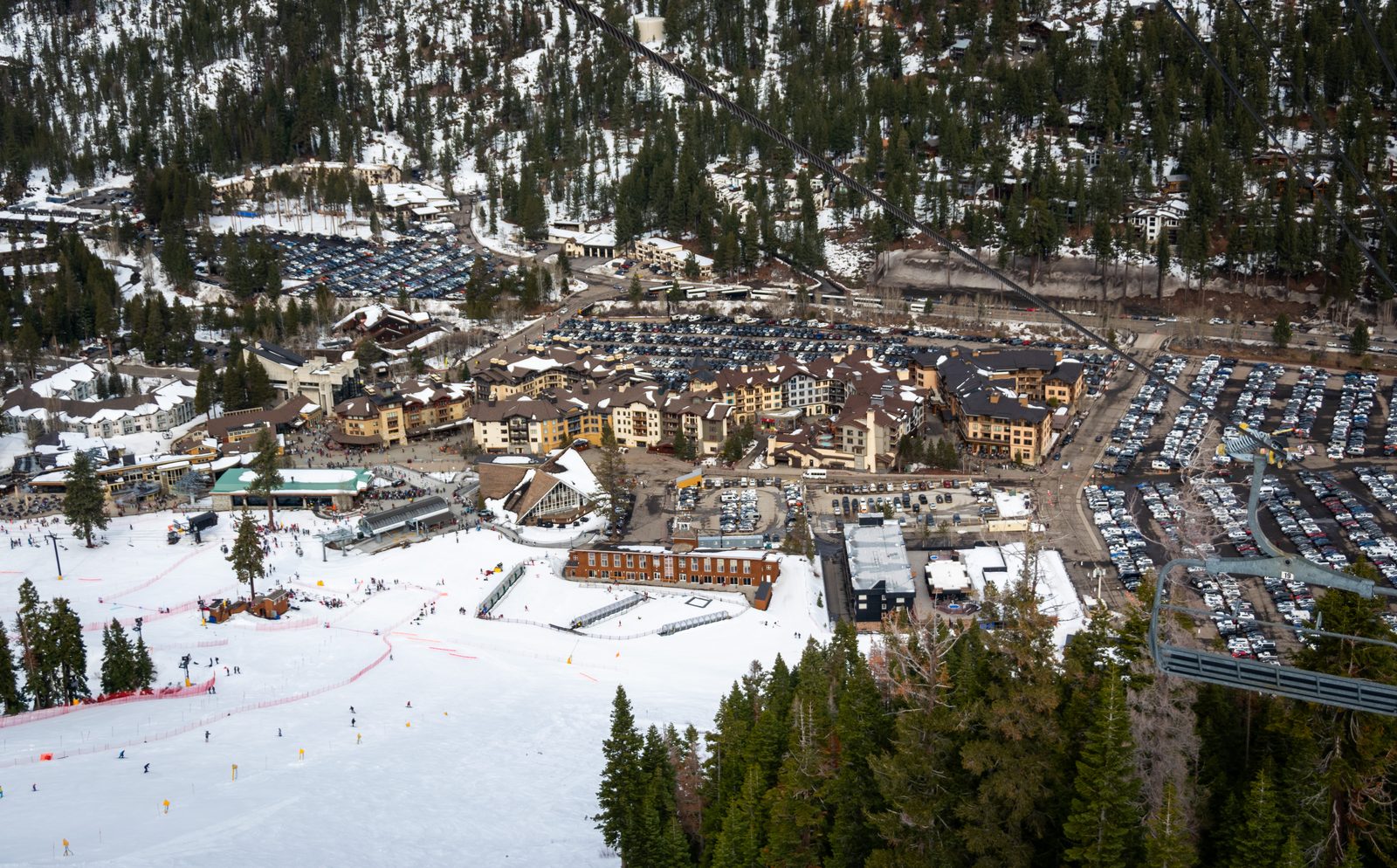 The base village at Palisades Tahoe (formerly Squaw Valley) ski resort, showing modern lodges and ski lifts against a mountain backdrop