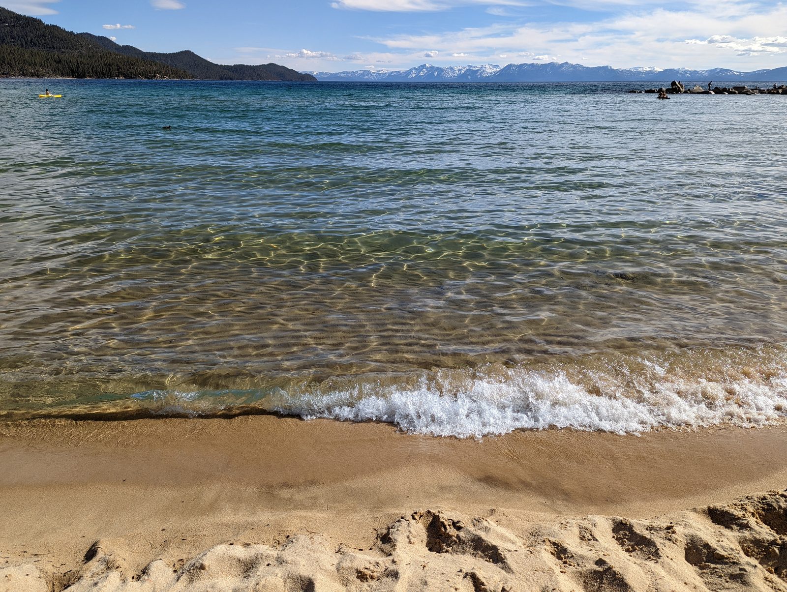 Sand Harbor's sandy beach on Lake Tahoe's east shore in Nevada, with clear turquoise water and granite boulders along the shoreline
