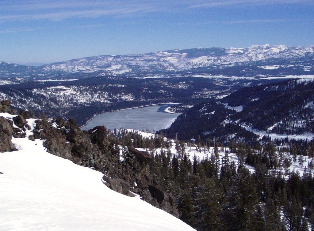 The Pioneer Monument and visitor area at Donner Memorial State Park in Truckee, California, with pine trees and Donner Lake nearby