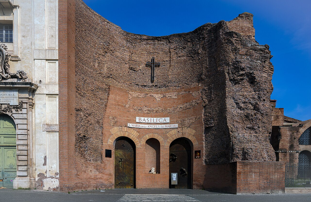 Wikipedia's Santa Maria degli Angeli e dei Martiri article showing a photo of the basilica's facade, built directly into the surviving brick ruins of the Baths of Diocletian