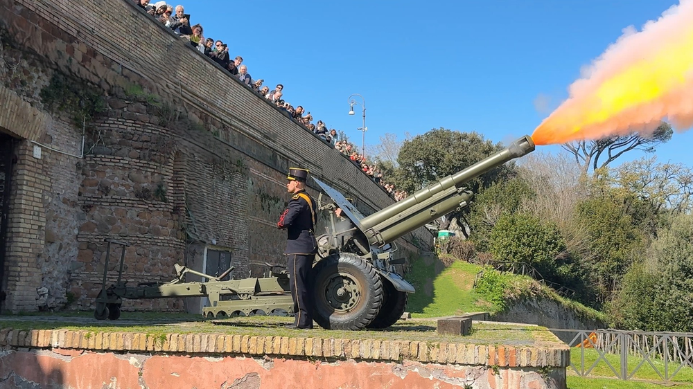 Turismo Roma page on the Janiculum Hill Cannon, showing a photo of an officer firing the cannon with a crowd of onlookers lined up along the wall above