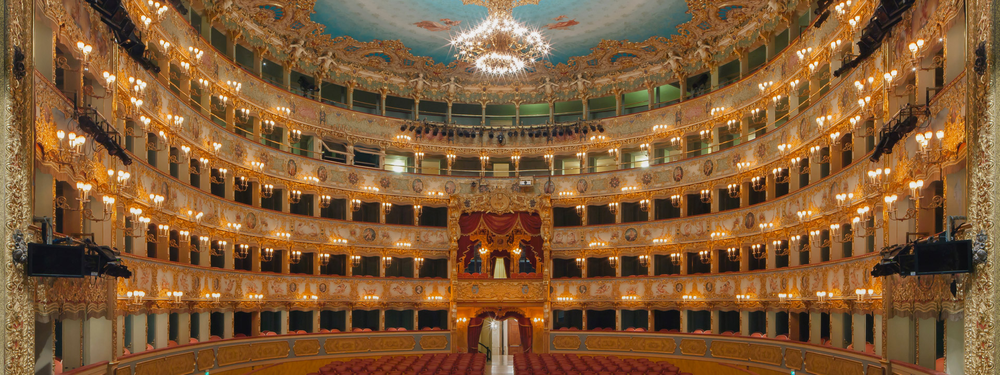 Teatro La Fenice's official visiting page, showing the ornate gilded interior of the opera house's auditorium and the tagline 'In Venice since 1792, I have risen two times from my ashes'
